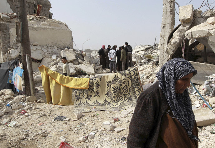 A woman walks at a site hit on Friday by what activists said was a Scud missile in Aleppo's Ard al-Hamra neighbourhood, February 23, 2013. Rockets struck eastern districts of Aleppo, Syria's biggest city, on Friday, killing at least 29 people and trapping a family of 10 in the ruins of their home, activists in the city said. (Reuters/Muzaffar Salman)