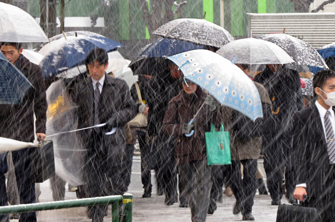 Commuters shelter from the snow under umbrellas whilst on their way to work in Tokyo on February 6, 2013. (AFP Photo/Kazuhiro Nogi)