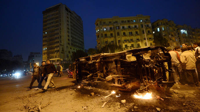 Egyptian look at a police vehicle that has been burnt by angry protesters following clashes with plainclothes policemen in Cairoâs on Tahrir square on March 3, 2013 (AFP Photo / Khaled Desouki)