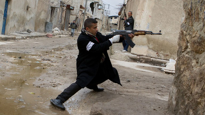 A Syrian rebel aims his weapon during clashes with government forces in the streets near Aleppo international airport in northern Syria on March 4, 2013. (AFP Photo / Stephen J. Boitano)