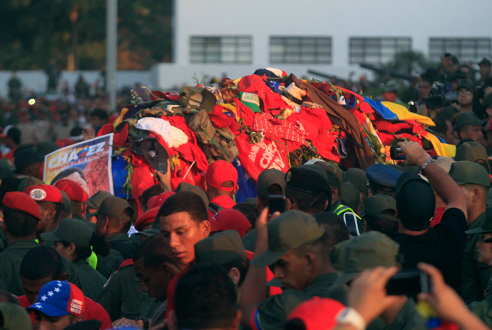 The coffin of late Venezuelan leader Hugo Chavez covered with clothes that people have thrown at it, is driven through the streets of Caracas, after leaving the military hospital where he died of cancer, March 6, 2013 (Reuters / Edwin Montilva)