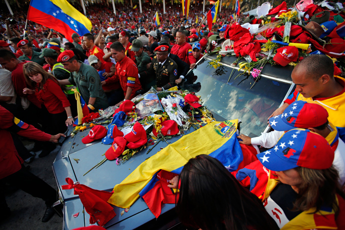 Caps and posters of late Venezuelan leader Hugo Chavez lie on the hood of the hearse that carried his coffin to the Military Academy, where his wake will be held, in Caracas March 6, 2013 (Reuters / Jorge Silva)