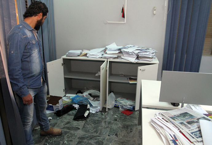 A Libyan man checks the site of a break-in at Alassema television station in Tripoli on March 7, 2013 (AFP Photo / Mahmud Turkia)