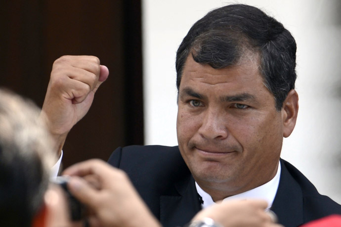 Ecuador's President Rafael Correa raises his clenched fist in salutation during the funeral of Venezuela's President Hugo Chavez in Caracas, on March 8, 2013. (AFP Photo/Juan Barreto)