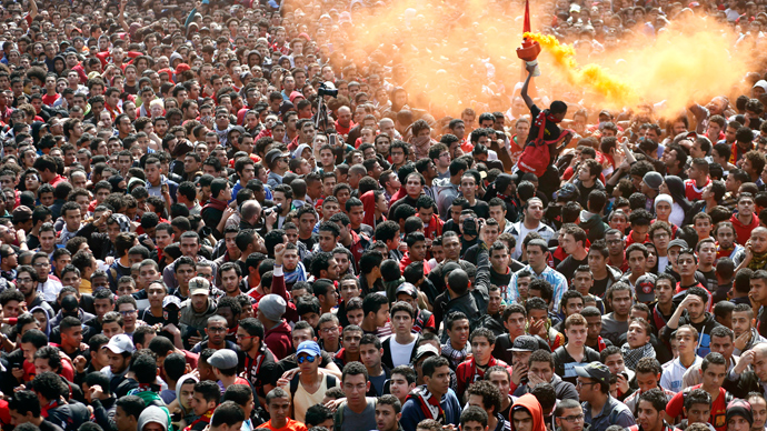 An Egyptian al-Ahly football club supporter (Ultras) lights a flare as they await the verdict of the court over a deadly football riot in Port Said that killed 74 people last year in Cairo on March 9, 2013 (AFP Photo / Mahmud Khaled)