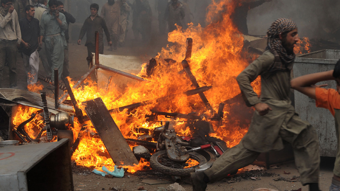 Angry Pakistani demonstrators gather around burning Christian's belongings during a protest over a blasphemy row in a Christian neighborhood in Badami Bagh area of Lahore on March 9, 2013 (AFP Photo / Arif Ali)