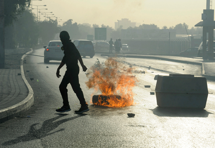 An anti-government protester walks away after setting up a road block on a highway during early hours of clashes in Budaiya, west of Manama March 14, 2013 (Reuters / Hamad I Mohammed)