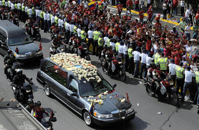 The hearse carrying the remains of late Venezuelan President Hugo Chavez heads to his resting place at the former "4 de Febrero" barracks -- a barracks-turned-museum that the former paratrooper had used as his headquarters during a failed 1992 coup attempt -- in Caracas, on March 15, 2013.(AFP Photo / Luis Camacho)