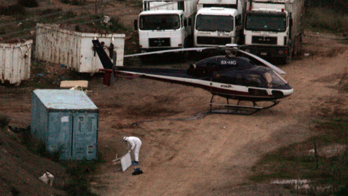 Police forensic experts investigate a helicopter used in the escape of convicts Vassilis Paleokostas and Alket Rizaj from Athens' high-security Korydallos prison, in north of Athens, on February 22, 2009 (AFP Photo)