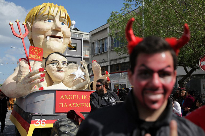 Cypriots walk past a papier-machà statue caricaturing German Chancellor Angela Merkel and President of Cyprus Nikos Anastasiadis, in an annual carnival in the southern city of Limassol, March 17, 2013. (AFP Photo / Yiannis Kourtoglou)