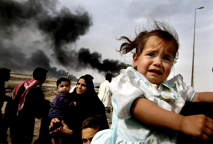 A March 30, 2003 file photo shows Iraqi families leaving Basra in southern Iraq, across one of the town's bridges manned by US soldiers. (AFP Photo/Dan Chung)