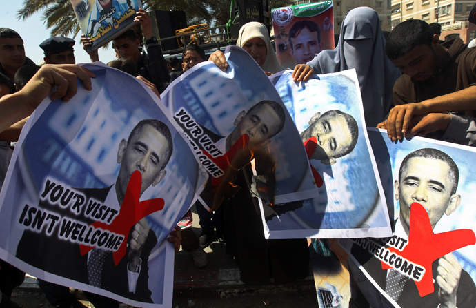 Relatives of prisoners of Palestinians held in Israeli jails burn pictures of US President Barack Obama during a protest against his visit to the region at the Jabalyia refugee camp, in the northern Gaza Strip, on March 20, 2013 (AFP Photo / Mahmud Hams)
