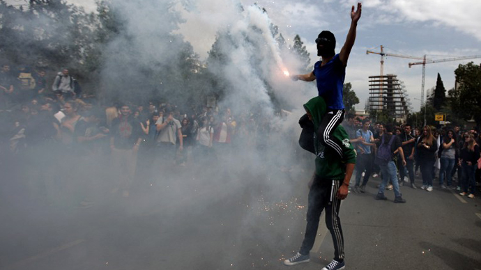 Cypriot college students light a flare outside the presidential palace during a protest in Nicosia against a bailout for the financially crippled island on March 26, 2013. (AFP Photo / Patrick Baz)
