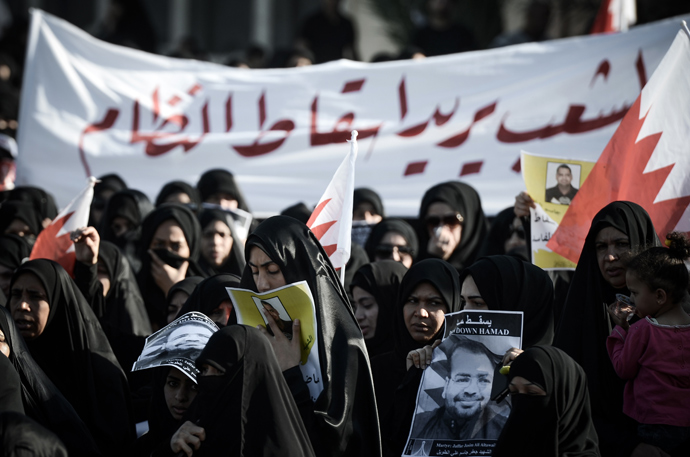 Bahraini mourners hold up a banner that reads in Arabic "The people want to overthrow the regime" during the funeral of Jaffar Jassim al-Taweel in the village of Sitra, south of Manama on March 27, 2013 (AFP Photo / Mohammed Al-Shaikh)