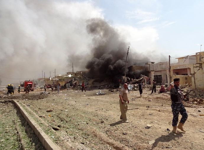 People look at a fire caused by a car bomb that detonated near a Shiite mosque killing three people and injuring 70 others on March 29, 2013 in Kirkuk.(AFP Photo / Marwan Ibrahim)