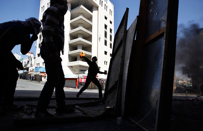 A Palestinian protester throws a Molotov cocktail during clashes with Israeli soldiers in the West Bank city of Hebron, after Maysara Abu Hamdeya, a Palestinian inmate died from cancer in an Israeli hospital on Tuesday April 2, 2013.(Reuters / Ammar Awad)