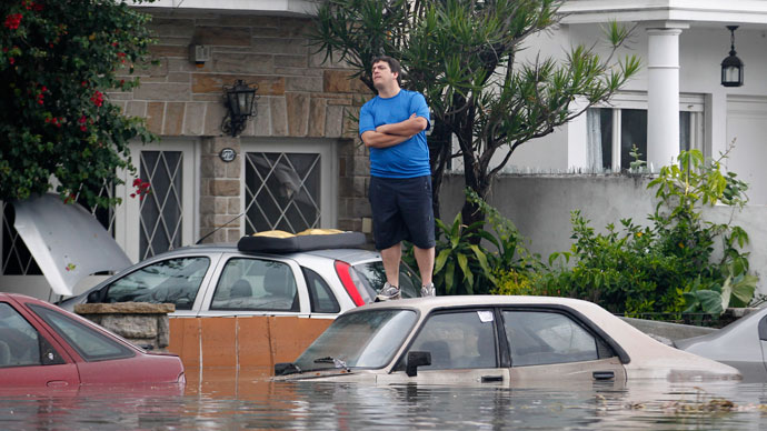 A man looks at cars in a flooded street after a rainstorm in Buenos Aires April 2, 2013.(Reuters / Enrique Marcarian)