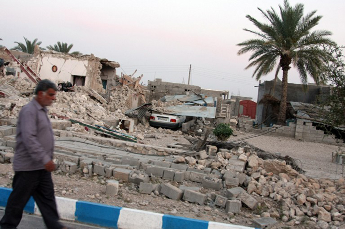 An Iranian man walks past the ruins of a destroyed house in the town of Shonbeh, southeast of Bushehr, on April 9, 2013. (AFP Photo)