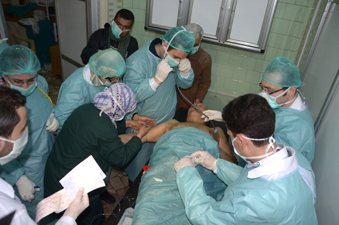 Medics and other masked people attend to a man at a hospital in Khan al-Assal in the northern Aleppo province, as Syria's government accused rebel forces of using chemical weapons for the first time on March 19, 2013 (AFP Photo / Sana)