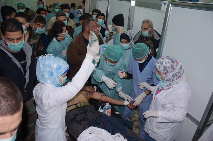 Medics and other masked people attend to a man at a hospital in Khan al-Assal in the northern Aleppo province, as Syria's government accused rebel forces of using chemical weapons for the first time on March 19, 2013 (AFP Photo / Sana)