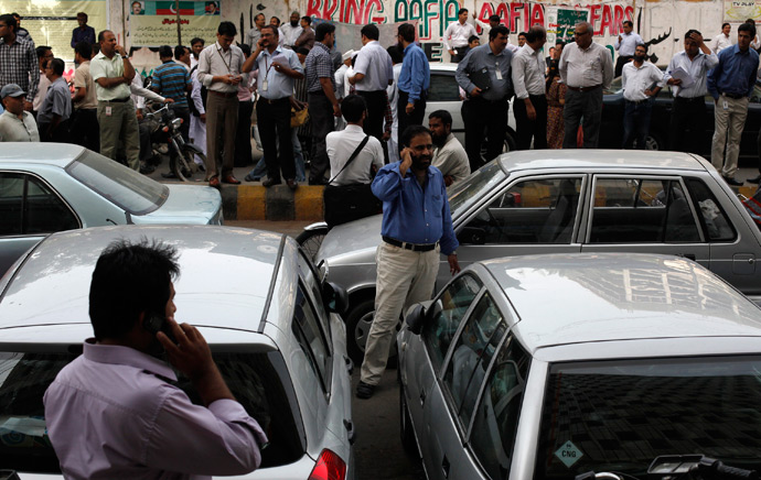 Office workers stand outside of their buildings following an earthquake tremor in Karachi April 16, 2013 (Reuters / Akhtar Soomro)