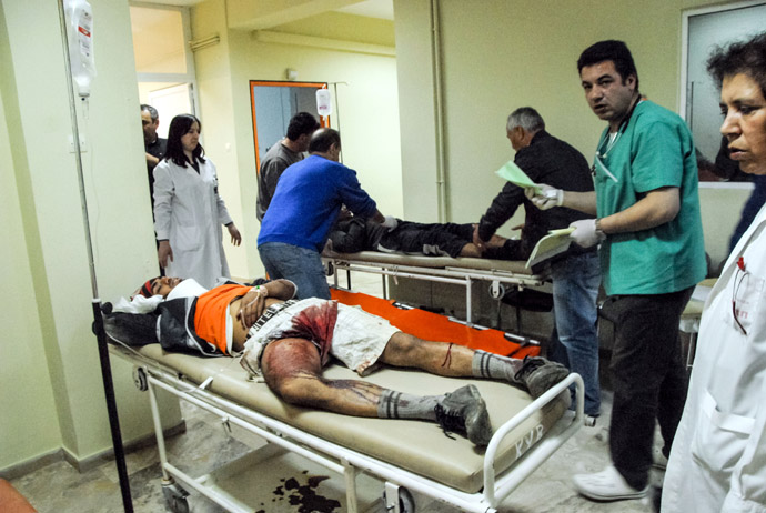 Two migrant workers receive first aid treatment after being shot on April 17, 2013 in Varda. (AFP Photo/Eurokinissi)