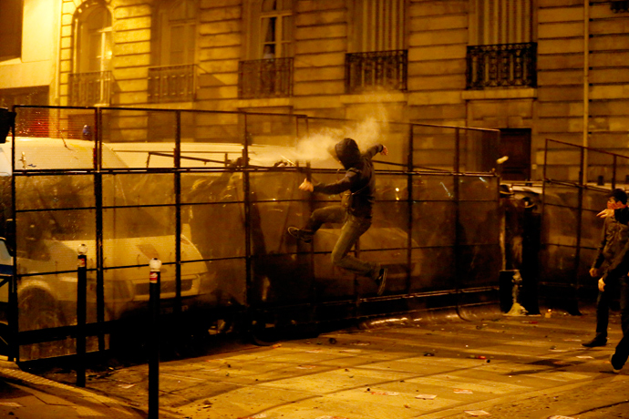 An opponent to the same sex marriage leaps against police barriers during a demonstration near the National Assembly, on April 23, 2013 in Paris (AFP Photo / Kenzo Tribouillard)