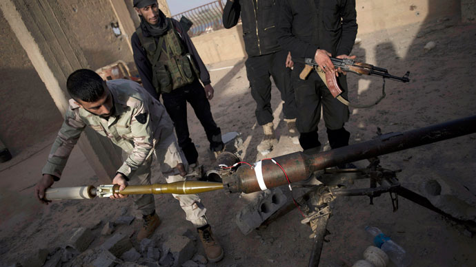 Syrian rebels of the Suqur Ali bin Aba Talib brigade prepare to launch a rocket from the roof of a building during ongoing clashes with regime forces.(AFP Photo / Zac Baillie)