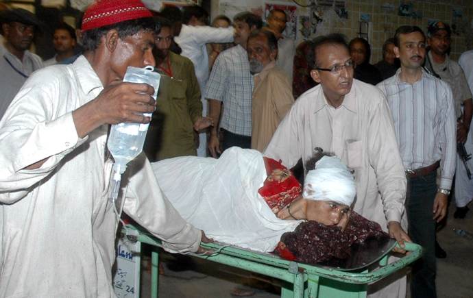 Pakistani men wheel an injured blast victim on a stretcher in a hospital following a bomb explosion in Karachi on April 27, 2013 (AFP Photo / Asif Hassan)