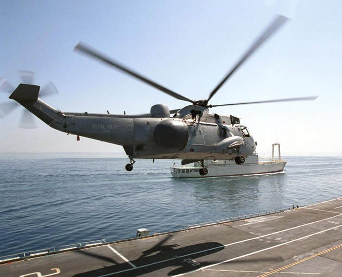 A British Royal Navy Sea King helicopter lands on the HMS Illustrious aircraft carrier off Oman's rugged coastline (AFP Photo)