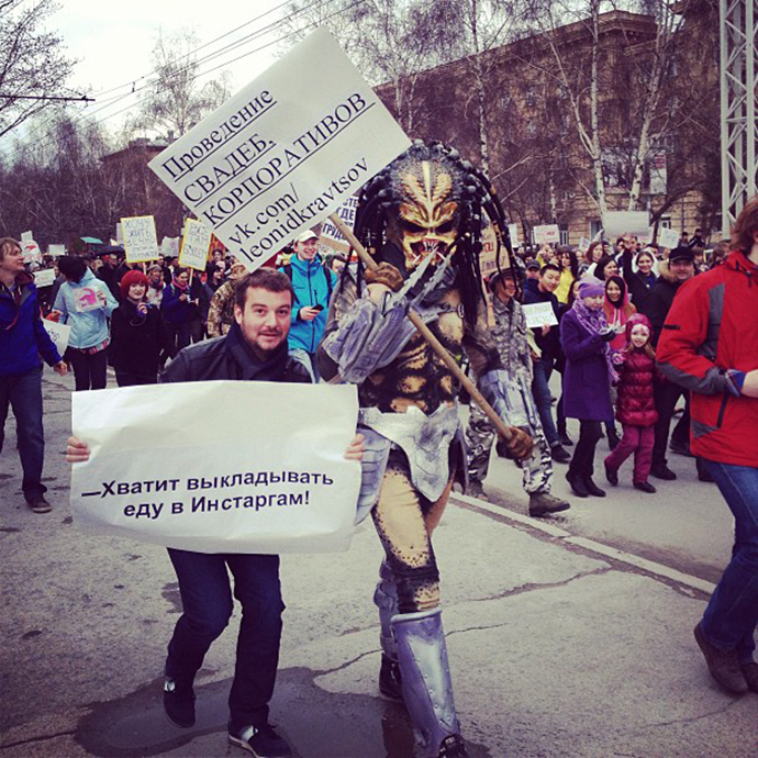 The man in a Predator costume holds a sign saying: âOrganization of weddings, corporate partiesâ, with the other Monstration participant demanding: âStop posting food on Instagram!â (Image from instagram user@artemtiunov)