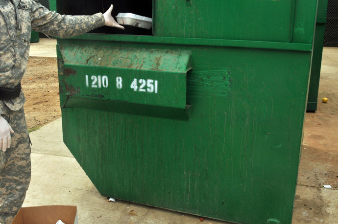 Guard Force soldier discards breakfast delivered earlier in the morning which was refused by detainees in Camps V and VI , Naval Station Guantanamo Bay, Cuba, April 10, 2013. (Image from publicintelligence.net / photo By Army Sgt. Brian Godette)