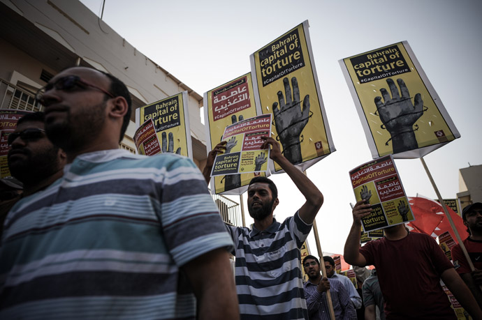 Bahraini protesters hold up placards and wave the national flag during an anti-government protests in the village of Jidhafs, west of Manama, on May 10, 2013. (AFP Photo)