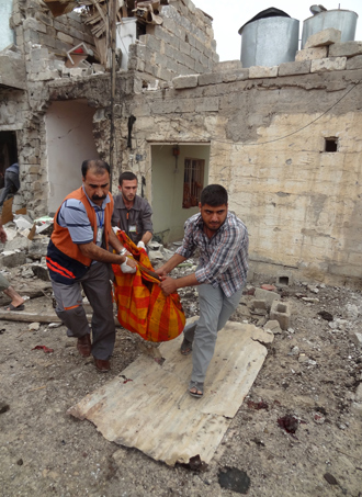 Iraqis carry human remains wrapped in a blanket at the site of a bombing in the northern city of Kirkuk on May 15, 2013 (AFP Photo / Marwan Ibrahim)