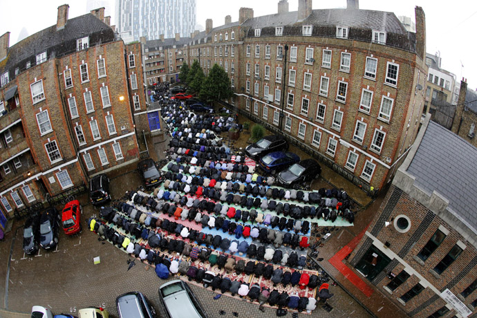 Muslims attend Friday prayers on a rainy first day of Ramadan, at the courtyard of a housing estate next to a small BBC community centre and mosque in east London (Reuters/Chris Helgren)