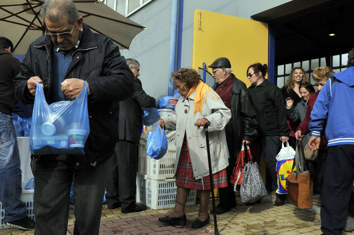 Poor and homeless people receive a bag with food after a New Year's dinner offered by the municipality of Athens.(AFP Photo / Louisa Gouliamaki)