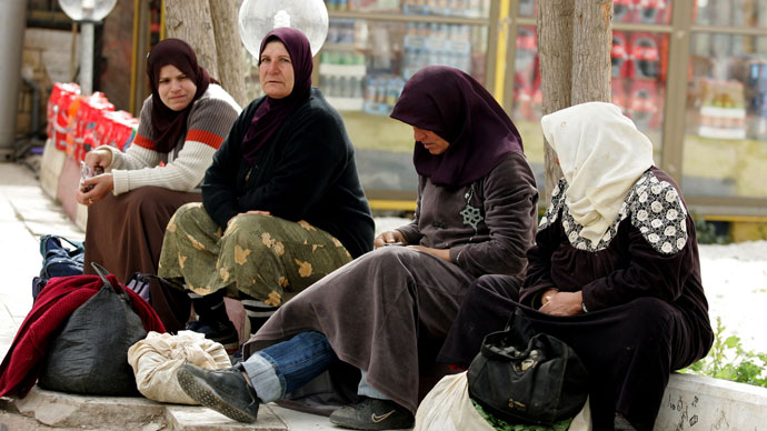 Palestinian women take a rest after crossing the Israeli Jalama checkpoint, near Jenin, as they return home to the West Bank after spending the day working in Israel .(AFP Photo / Saif Dahlah)