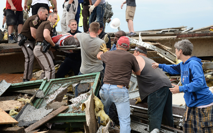 Rescue workers help free one of 15 people trapped in a medical building at the Moore hospital complex after a tornado tore through the area of Moore, Oklahoma May 20, 2013 (Reuters / Gene Blevins)