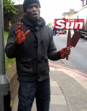 One of the men involved in the attack and murder of a man believed to be a serving British soldier, gesturing as he speaks following the attack in Woolwich, London on May 22, 2013.(AFP Photo / THE SUN)