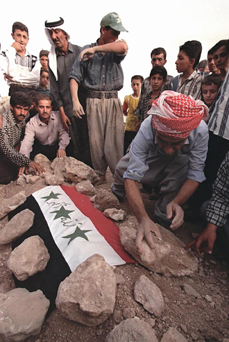 Iraqis bury one of the body of people killed in an alleged US and Britain attack in the village of Tel Afr, 45 kilometers (28 miles) west of Mosul. (AFP Photo / Azdin Hussein)