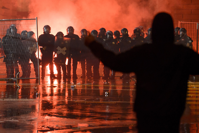 A member of the Black bloc faces riot police in front of the Swiss House of Parliament on late May 25, 2013 in the center of Switzerland's capital Berne during the 3rd edition of "Tanz Dich Frei" (Dance Yourself Free) a politically-tinged techno parade and mass unauthorised rally (AFP Photo / Fabrice Coffrini)