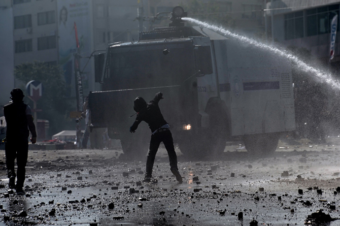 A protester throws a stone at a water canon during clashes with riot police in istanbul's Taksim square on June 11, 2013 (AFP Photo/ Aris Messinis)