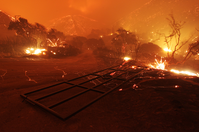 Wind-blown embers fly around fallen gates immediately after the main fire front sweeps over in a fast run toward Lake Hughes on June 1, 2013 south of Lake Hughes, California (AFP Photo / David McNew)