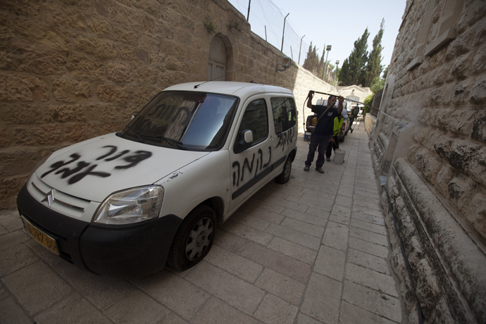 Jerusalem municipality workers clean anti-Christian graffiti that was daubed on the Church of the Dormition, one of Jerusalem's leading pilgrimage sites, early on May 31, 2013 (AFP Photo / Ahmad Gharabli)