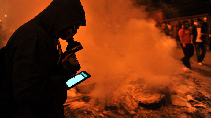 A protestor uses a mobile phone to give latestt news about the clashes near Taksim in Istanbul on June 3, 2013. (AFP Photo / Ozan Kose)