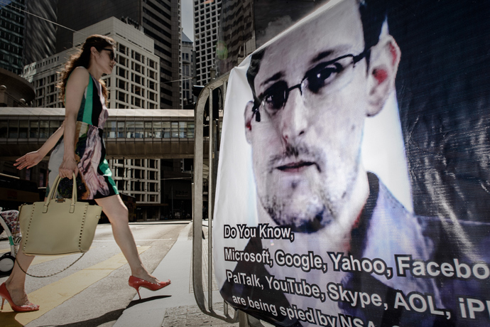 A woman walks past a banner displayed in support of former US spy Edward Snowden in Hong Kong on June 18, 2013 (AFP Photo / Philippe Lopez)