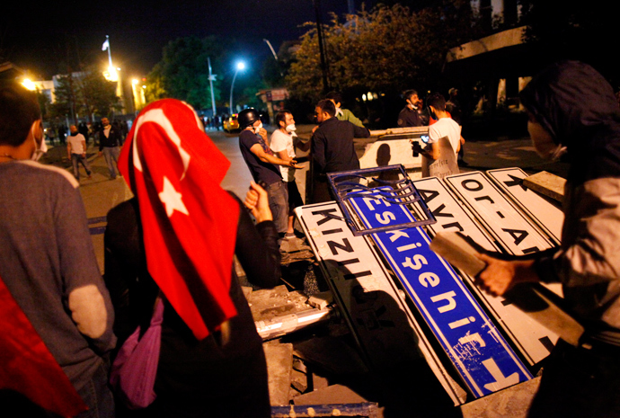 Anti-government protesters use road signs and cement blocks from a damaged sidewalk to set up a barricade, used to block riot police vehicles, during a protest in Kennedy street in central Ankara June 13, 2013 (Reuters / Dado Ruvic)