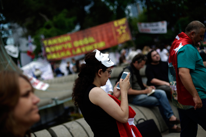 A protester uses her mobile device as she walks at Gezi Park on Taksim Square in Istanbul (Reuters / Stoyan Nenov)