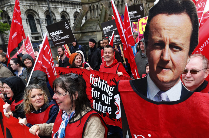 A demonstrator holds a placard depicting Britain's Prime Minister David Cameron (C) during a protest against the upcoming G8 summit, to be held near Enniskillen, in Belfast June 15, 2013. (Reuters)