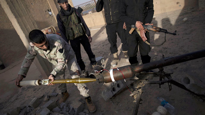 Syrian rebels of the Suqur Ali bin Aba Talib brigade prepare to launch a rocket from the roof of a building during ongoing clashes with regime forces.(AFP Photo / Zac Baillie)